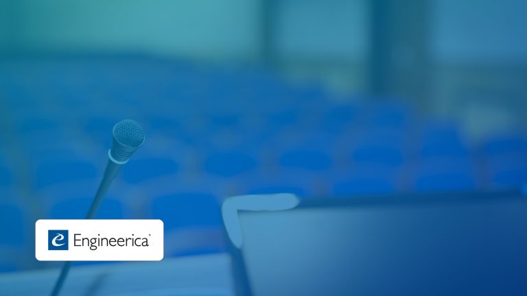 Close-up microphone at a podium with a blurred blue auditorium and Engineeria branding in the corner.